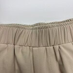 Close-up of beige women's pants with elastic waistband, showcasing comfortable and stylish casual wear.