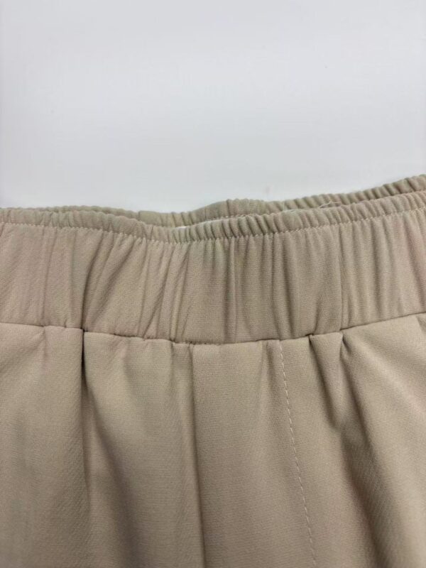 Close-up of beige women's pants with elastic waistband, showcasing comfortable and stylish casual wear.