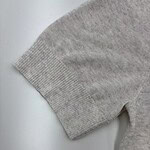 Close-up of a gray sweater sleeve showing ribbed cuff and soft knit fabric, ideal for casual fashion and comfortable wear.