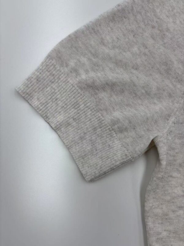 Close-up of a gray sweater sleeve showing ribbed cuff and soft knit fabric, ideal for casual fashion and comfortable wear.