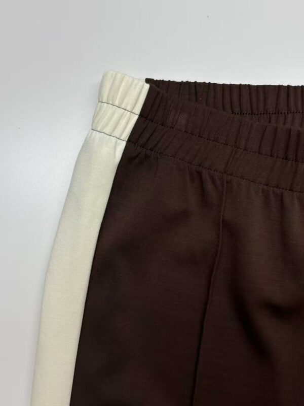 Close-up of stylish casual sweatpants with elastic waistband, beige and dark brown colors, suitable for comfortable everyday wear.
