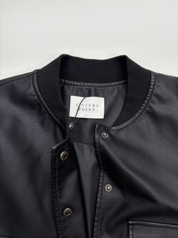Close-up of a black leather bomber jacket with snap buttons and ribbed collar, perfect for casual and streetwear fashion.