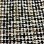 Close-up of checkered wool fabric in black, white, and brown tones, ideal for stylish clothing and accessories.