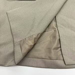 Close-up of beige suit fabric showing detailed texture and lining, ideal for formal wear or business attire.