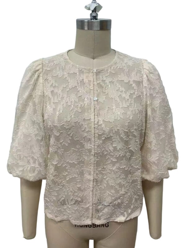 Elegant cream lace blouse with puff sleeves and intricate floral pattern, perfect for formal or special occasions.