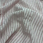 Close-up of a soft pink fabric with white stripes and scattered rhinestones, showcasing a luxurious and delicate texture suitable for fashion design.