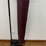 Side view of stylish burgundy leather pants with elastic waistband, perfect for fashion-forward women seeking luxury and comfort.