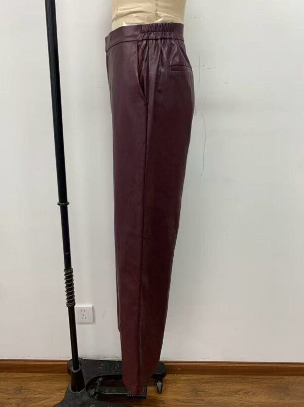 Side view of stylish burgundy leather pants with elastic waistband, perfect for fashion-forward women seeking luxury and comfort.