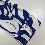 Close-up of a blue and white patterned shirt sleeve with buttons, showcasing fashionable casual wear.