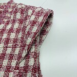 Close-up of pink and white checkered fabric with textured pattern, suitable for fashion or home decor projects.