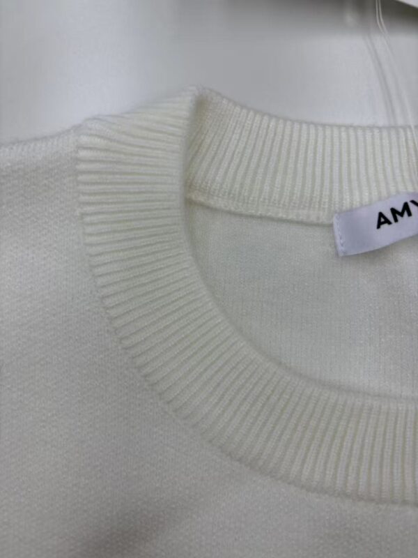 Close-up of a white sweater with a ribbed neckline, showcasing high-quality knit fabric suitable for stylish casual wear.