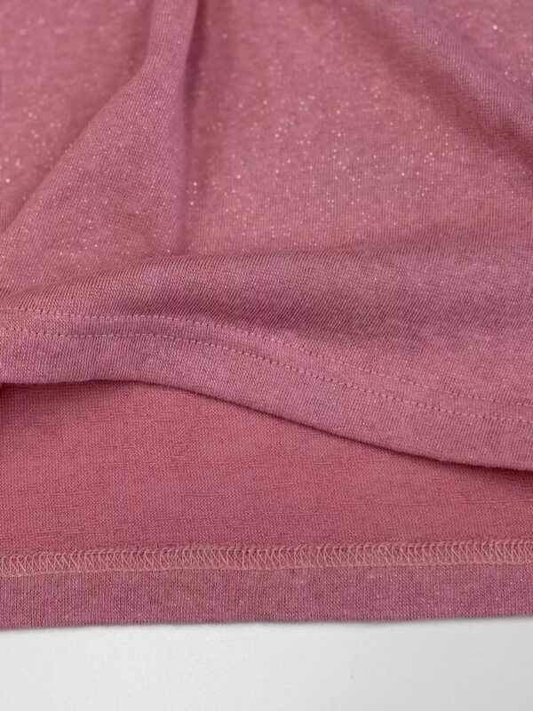 Close-up of pink fabric with glittery texture, suitable for clothing and fashion accessories.