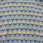 Light blue knitted sweater featuring a repeating pattern of yellow and black floral motifs, perfect for casual wear and cold weather.
