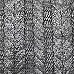 Detailed close-up of gray knitted fabric with braided cable patterns, showcasing texture and craftsmanship.