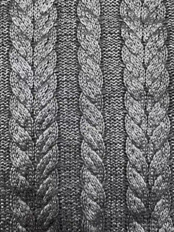 Detailed close-up of gray knitted fabric with braided cable patterns, showcasing texture and craftsmanship.