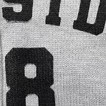 Detailed close-up of a sports jersey showing the number 8 in bold black font on a textured fabric background.