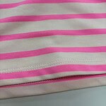 Close-up of pink and white striped fabric, showcasing the pattern and texture, ideal for fashion or textile product descriptions.