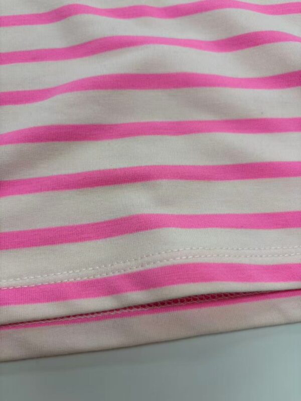 Close-up of pink and white striped fabric, showcasing the pattern and texture, ideal for fashion or textile product descriptions.