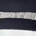 Close-up of stylish knitwear featuring textured patterns and contrasting black and beige colors, perfect for fashion-forward outfits.