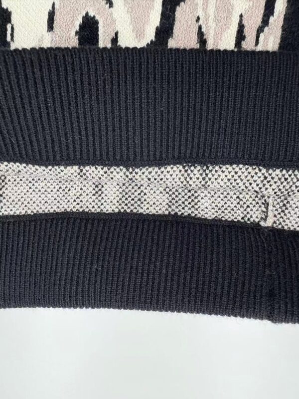 Close-up of stylish knitwear featuring textured patterns and contrasting black and beige colors, perfect for fashion-forward outfits.