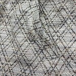 Close-up of snake print fabric showcasing intricate pattern and texture, ideal for stylish clothing and accessories.