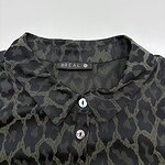 Close-up of a stylish black and olive green animal print shirt with a collar and buttons, perfect for casual or chic outfits.