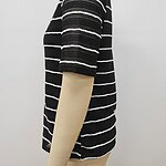 Close-up of a black and white striped knit sweater displayed on a mannequin, showcasing the textured fabric and pattern.