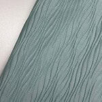 Close-up of soft green fabric with a textured, wavy pattern, ideal for fashion and apparel design.