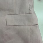 Close-up of a beige suit with a flap pocket, showcasing tailored fabric and professional style, ideal for business or formal occasions.