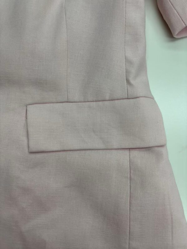 Close-up of a beige suit with a flap pocket, showcasing tailored fabric and professional style, ideal for business or formal occasions.
