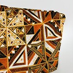 Close-up of vibrant African tribal pattern fabric with geometric shapes in orange, black, and white, ideal for fashion and cultural clothing designs.