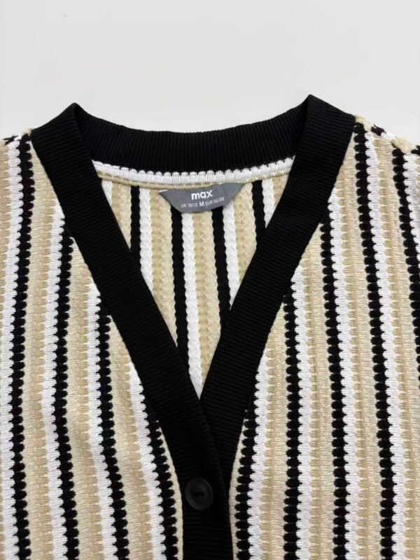 Close-up of a women's striped knit cardigan with black, white, and beige vertical patterns, featuring a V-neck and button closure.