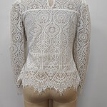 Elegant white lace blouse with intricate floral patterns, long sleeves, and a keyhole neckline, perfect for formal or special occasions.