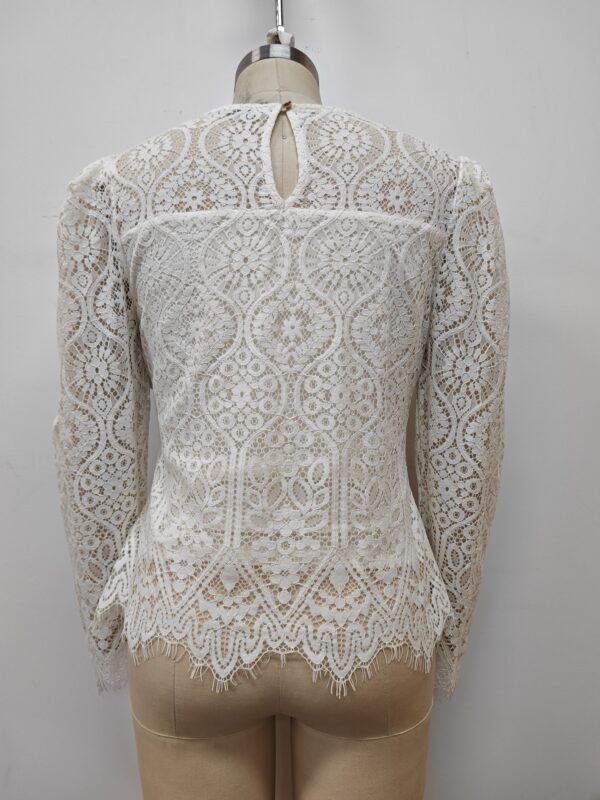 Elegant white lace blouse with intricate floral patterns, long sleeves, and a keyhole neckline, perfect for formal or special occasions.