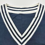 Close-up of a navy blue V-neck sweater featuring white and navy striped collar, showcasing stylish casual fashion for men and women.