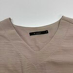 Beige V-neck women's top with subtle texture, perfect for casual or office wear, displayed on a plain background.