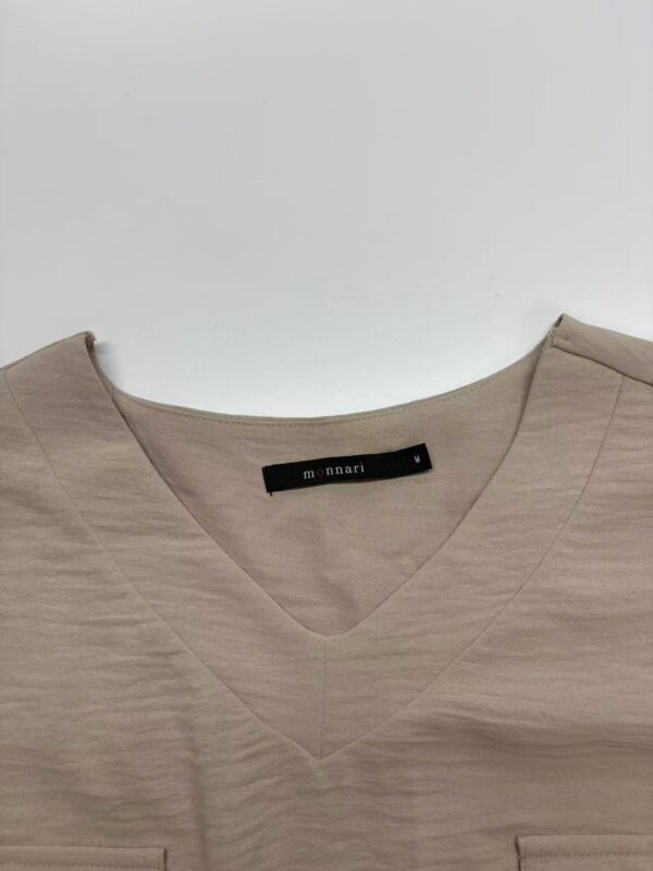 Beige V-neck women's top with subtle texture, perfect for casual or office wear, displayed on a plain background.