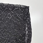 Close-up of black fabric adorned with intricate beadwork, perfect for high-end fashion designs and evening wear.