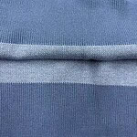 Close-up of blue fabric with detailed knit pattern, showcasing texture and quality suitable for fashion and clothing manufacturing.