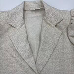 Close-up of a stylish grey blazer with a notched lapel, tailored fit, and single-button closure, perfect for professional or casual wear.