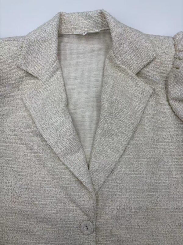 Close-up of a stylish grey blazer with a notched lapel, tailored fit, and single-button closure, perfect for professional or casual wear.