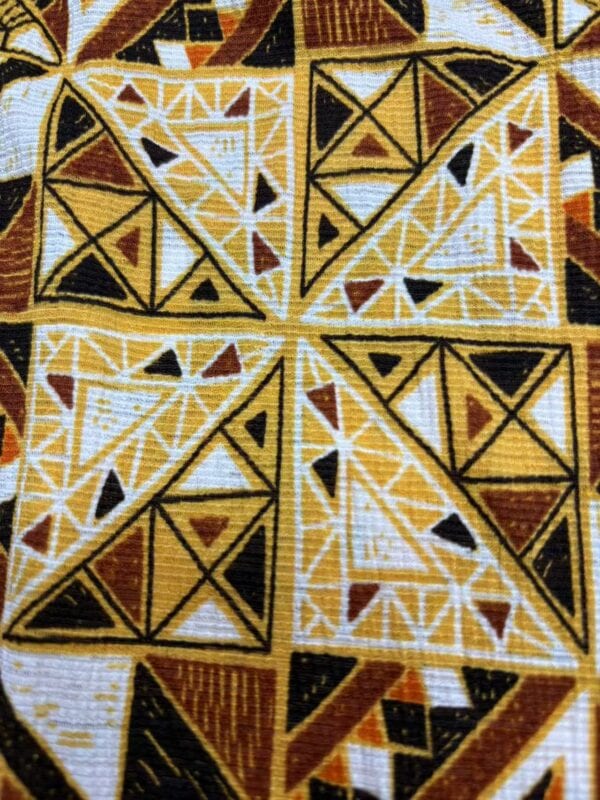 Vibrant fabric featuring intricate geometric patterns in yellow, black, white, and brown colors, showcasing detailed craftsmanship and vibrant design.