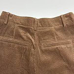 Close-up of brown corduroy pants showing back pockets and waistband, suitable for casual or semi-formal wear.