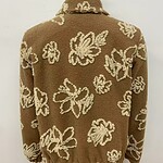 Cozy brown sweater with white floral pattern, ideal for fall and winter fashion, displayed on a mannequin against a plain background.