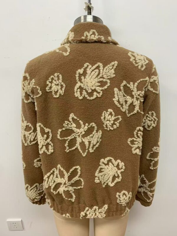 Cozy brown sweater with white floral pattern, ideal for fall and winter fashion, displayed on a mannequin against a plain background.