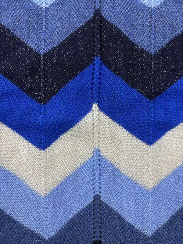 Close-up of blue and black chevron knit fabric with detailed stitching, ideal for stylish clothing and accessories.