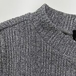 Close-up of a grey knitted sweater with a V-neck, showcasing textured fabric and fine detailing, perfect for casual or office wear.