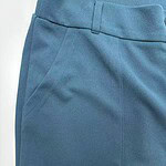 Close-up of blue men's pants showing fabric texture and pocket detail, perfect for casual or business wear.