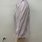 Side view of a light pink linen blouse with long sleeves and a classic collar, displayed on a mannequin against a plain white background.