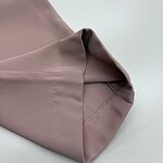 Close-up of taupe dress fabric showing smooth texture and neat stitching, ideal for fashion and clothing design.